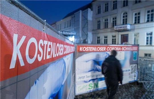 Ein Passant geht an einem Corona-Testzentrum im Schweriner Stadtzentrum vorbei.