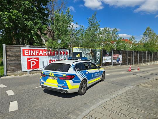 Ein Polizeiauto steht in der Zufahrt zur Tiefgarage eines Baumarkts, wo die Leiche einer Frau im Kofferraum eines Autos gefunden worden ist.