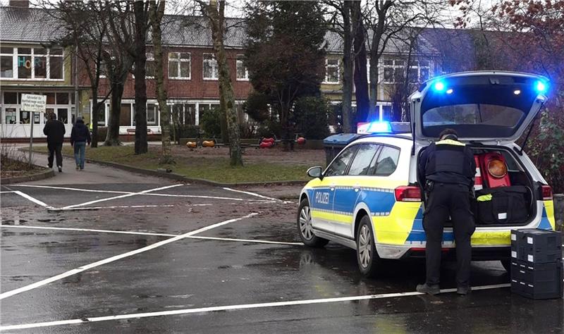 Ein Polizeiauto steht vor dem Gebäude einer  Grund- und Hauptschule in Lüdingworth. Dort hat ein Mädchen ein anderes mit einem Messer schwer verletzt.