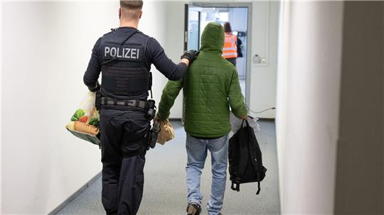 Ein Polizeibeamter bringt einen Mann zu einem Abschiebeflug nach Pakistan. (Archivfoto)