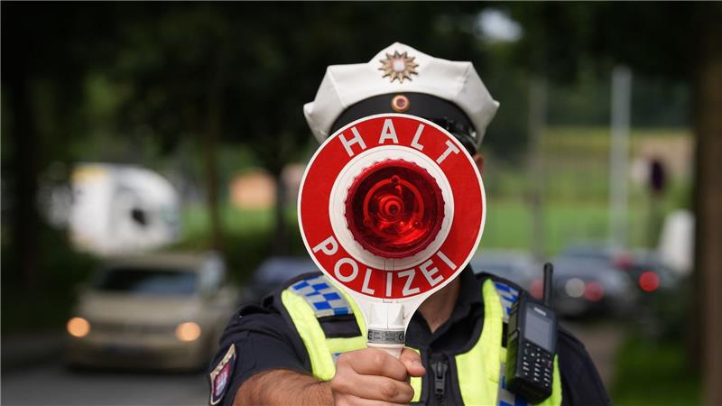 Bilder des Tages Ein Polizeibeamter hält einen Anhaltestab in einer 30er-Zone während des Blitzermarathons im Stadtteil Wilhelmsburg.