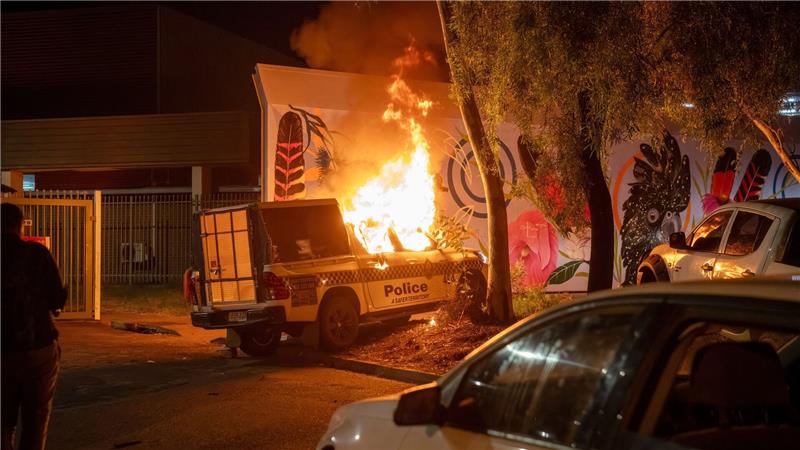Ein Polizeifahrzeug brennt vor dem Krankenhaus in Alice Springs.