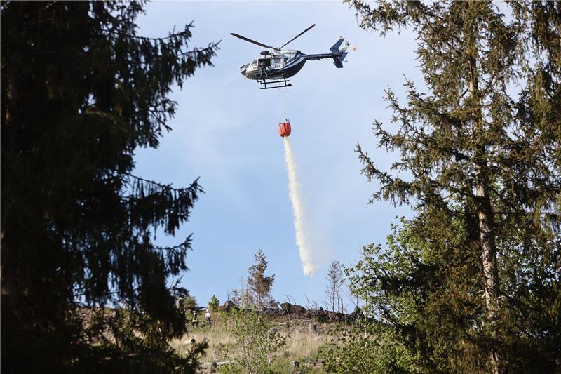 Erneuter Waldbrand im Harz: Ursache unklar Ein Polizeihubschrauber bringt Wasser zum Löschen an einen Waldbrand bei Stiege im Harz.