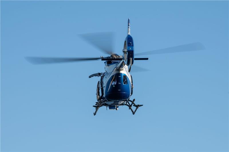 Ein Polizeihubschrauber fliegt im Rahmen eines Trainings über ein Gewässer.