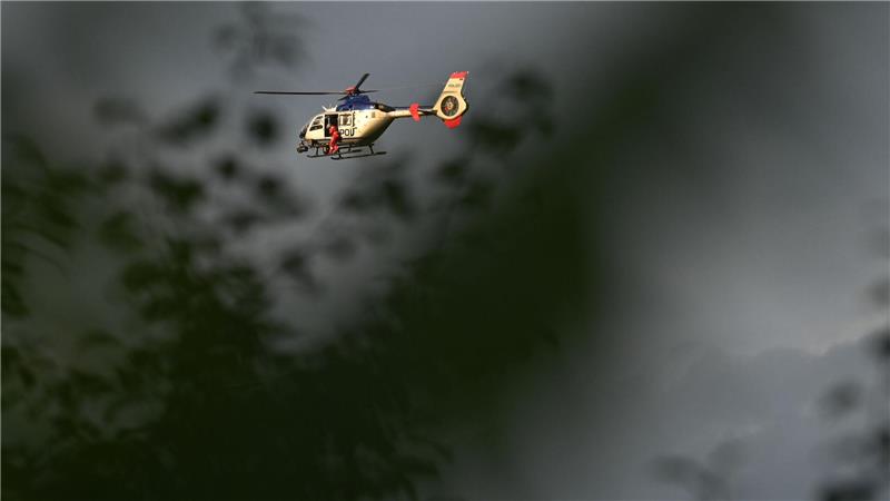 Bilder des Tages Ein Polizeihubschrauber kreist über der Absturzstelle eines Bundeswehrhubschraubers in Sachsen, auf der Suche nach einem noch Vermissten.