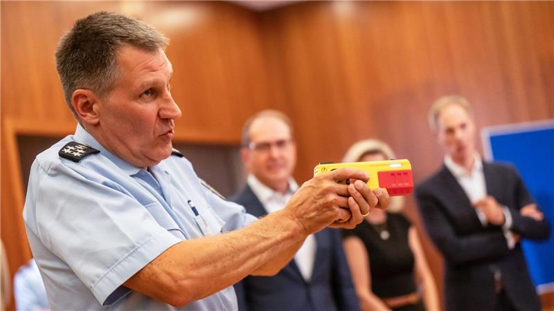 Ein Polizist erklärte die Funktionsweise eines Distanz-Elektroimpulsgeräts im vergangenen Jahr im Innnenministerium. (Archivfoto)