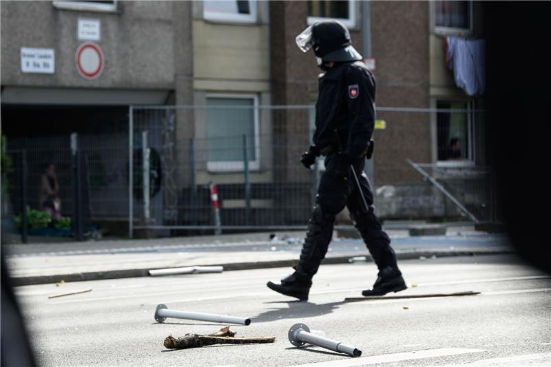 Illegale Abriegelung von Wohnblock: Schmerzensgeldforderung Ein Polizist geht an Metall- und Holzgegenständen vorbei, die vor einem unter Quarantäne gestellten Wohngebäude in der Göttinger Innenstadt auf dem Boden liegen.