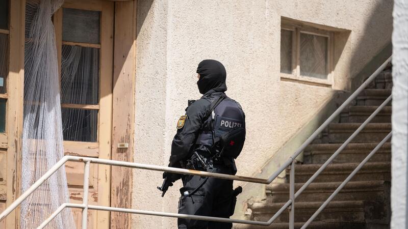 Ein Polizist ist bei der Suche nach Beschuldigten im baden-württembergischen Althengstett im Einsatz.