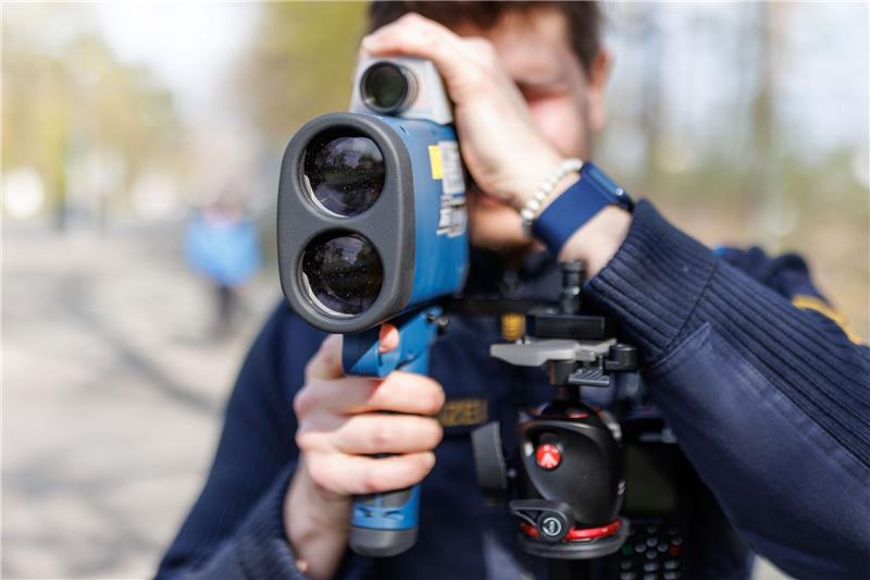 Am Tag des Bahn-Streiks geht Polizei gezielt gegen Raser vor Ein Polizist schaut während des sogenannten Blitzmarathons durch ein Laserhandmessgerät.