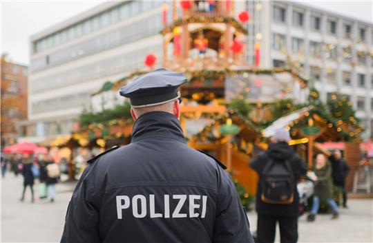 Ein Polizist steht an der Weihnachtspyramide am Kröpcke in Hannover. In Niedersachsen ist ein 20-Jähriger festgenommen worden, der einen Terroranschlag in der Weihnachtszeit geplant haben soll.