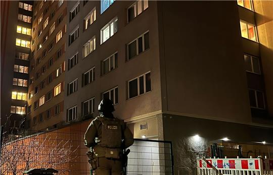 Ein Polizist steht vor dem Studentenwohnheim in Berlin-Friedrichshain, in dem eine Wohnung durchsucht wurde.