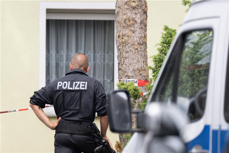 Ein Polizist steht vor einem Wohnhaus. Nach dem Fund einer Leiche in einem Haus ermittelt die Mordkommission zu einem Gewaltverbrechen. Foto: dpa
