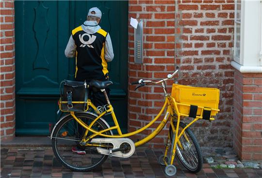 Ein Postbote verteilt Briefe in Lüneburg. Postboten und Paketzusteller der Deutschen Post sollen nach Ansicht der Gewerkschaft Verdi 15 Prozent mehr Geld bekommen.