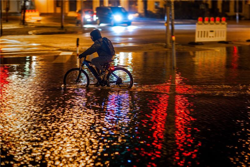 Schwere Sturmflut setzt der Ostsee-Küste zu - Eine Tote Ein Radfahrer fährt durch das Hochwasser am Stadthafen von Wismar.