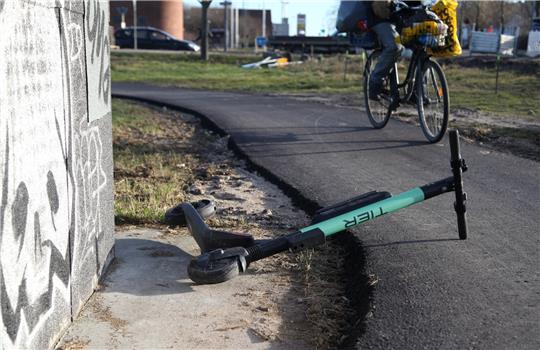 Ein Radfahrer weicht auf einem Radweg einem umgekippten E-Scooter aus. Symbolfoto: picture alliance/dpa | Steffen Trumpf