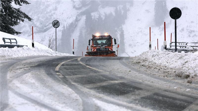 Ein Räumfahrzeug des Winterdienstes fährt auf dem Riedbergpass im Schneetreiben.