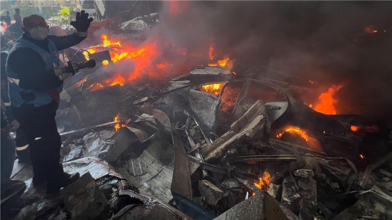 Ein Rettungsarbeiter löscht brennende Autos am Ort eines israelischen Luftangriffs im Zentrum von Beirut.