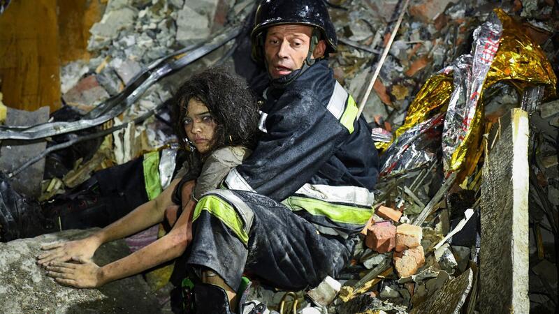 Ein Rettungshelfer zieht ein verletztes Mädchen aus den Trümmern eines durch einen russischen Ankriff beschädigten Hotels in Saporischschja.