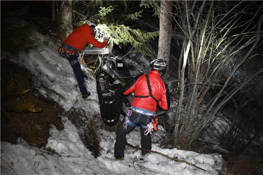 Ein Rettungsteam arbeitet an der Unglückstelle nach einem nächtlichen Unfall mit einem Motorschlitten.