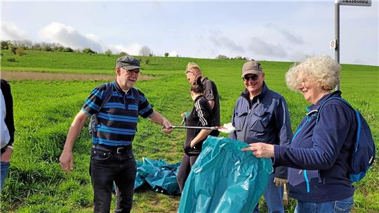 Ein Rückblick auf 2024: Freiwillige sammeln den Müll aus Wäldern und Feldern und finden Toilettenschüsseln, jede Menge Autoreifen und achtlos Weggeworfenes, das viele blaue Müllsäcke füllt.