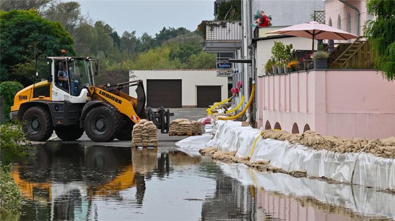 Hochwasser steigt - Erste Straßen an der Oder überflutet Ein Sandsack-Wall wird in einem Stadtteil von Eisenhüttenstadt verstärkt. Dort hat das Hochwasser Straßen überflutet.