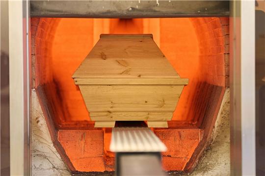 Ein Sarg wird in einem Krematorium verbrannt.