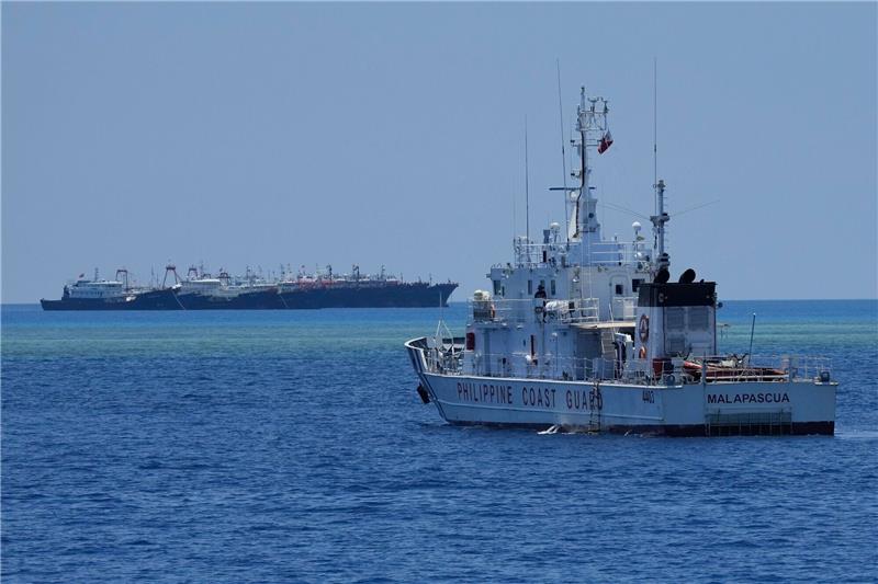 Philippinen werfen China „aggressive Taktiken” vor Ein Schiff der philippinischen Küstenwache nähert sich einigen der vielen mutmaßlichen chinesischen Milizschiffe an dem von den Philippinen beanspruchten Riff namens Whitsun.