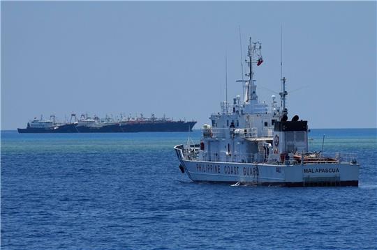 Ein Schiff der philippinischen Küstenwache nähert sich einigen der vielen mutmaßlichen chinesischen Milizschiffe an dem von den Philippinen beanspruchten Riff namens Whitsun.
