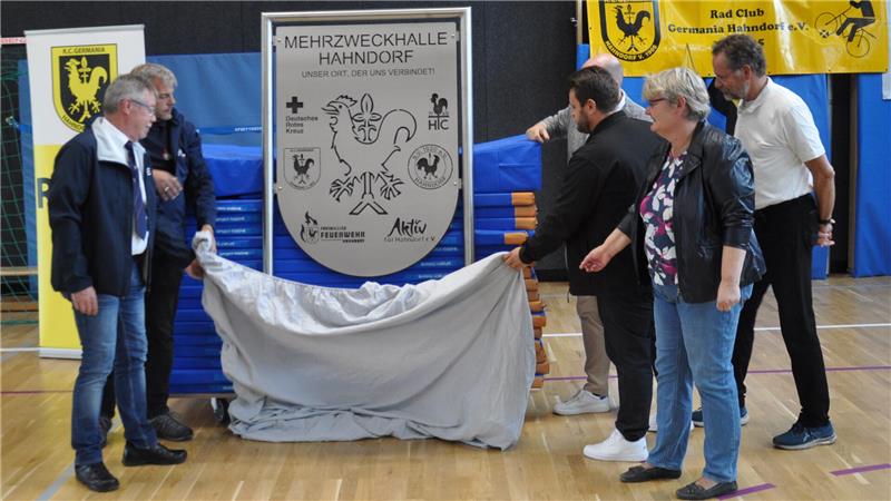 Ein Schild für die Halle: Hahndorfer Vereinsvertreter enthüllen den schicken neuen Metallschmuck.