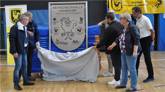 Ein Schild für die Halle: Hahndorfer Vereinsvertreter enthüllen den schicken neuen Metallschmuck.