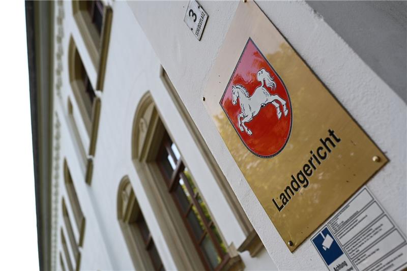 Zwei Polizisten wegen Körperverletzungen im Amt vor Gericht Ein Schild mit dem niedersächsischen Landeswappen hängt am Eingang zum Landgericht Aurich.