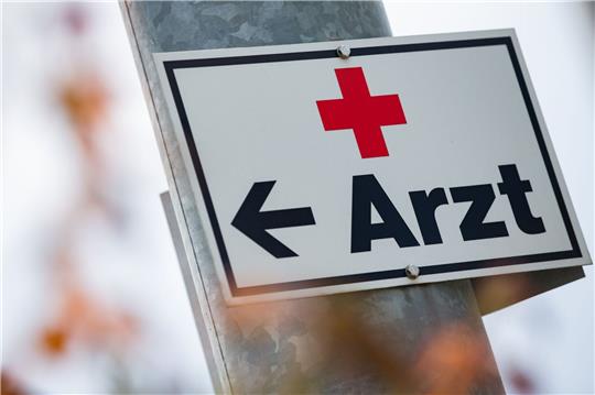 Ein Schild mit der Aufschrift «Arzt» hängt an einer Straßenlaterne.