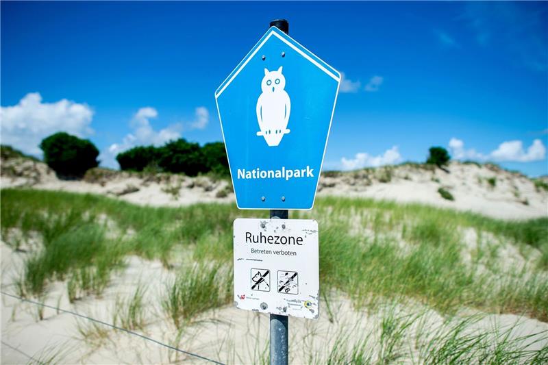Ein Schild mit der Aufschrift «Nationalpark» steht vor der Dünenlandschaft am Ostende der Insel Norderney.
