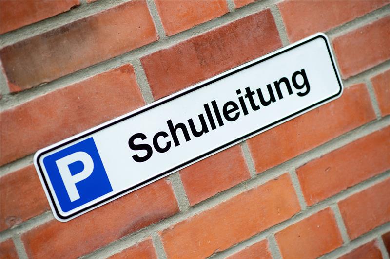 Ein Schild mit der Aufschrift Schulleitung hängt vor einer Parkfläche. Foto: picture alliance/dpa | Hauke-Christian Dittrich
