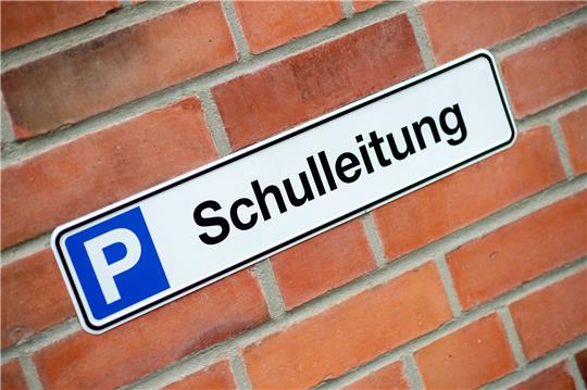 Ein Schild mit der Aufschrift Schulleitung hängt vor einer Parkfläche. Foto: picture alliance/dpa | Hauke-Christian Dittrich