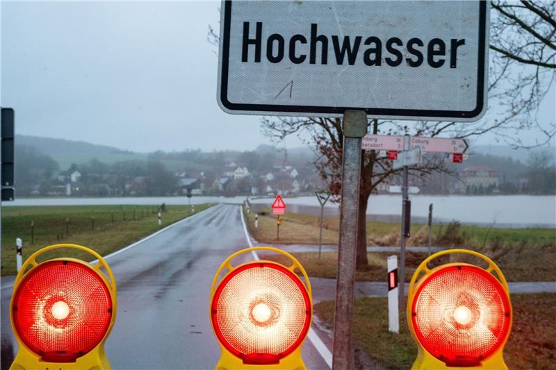 Ein Schild warnt vor Hochwasser, die Straße ist gesperrt.