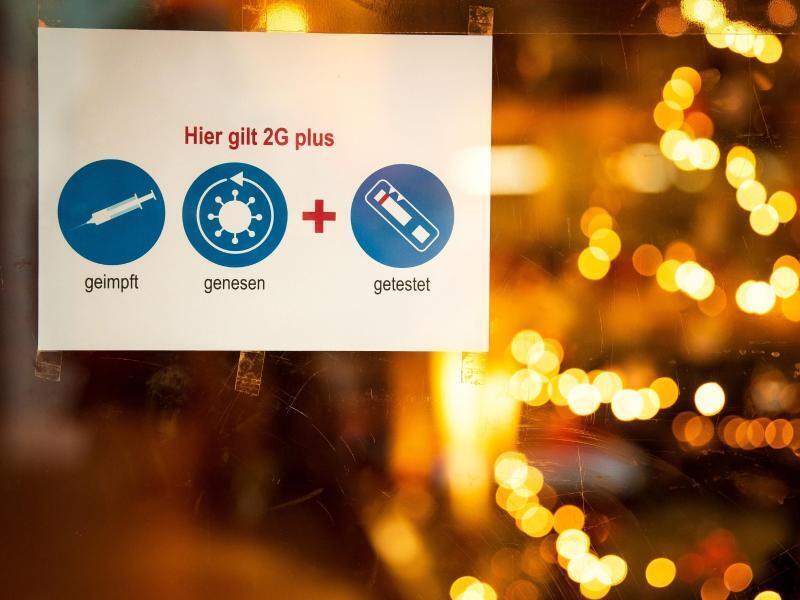 Ein Schild weist auf die 2G-Plus-Regel hin. Foto: Sina Schuldt/dpa