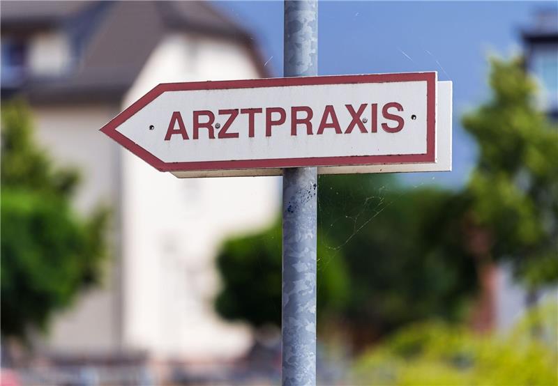 Ein Schild weist den Weg zu einer Arztpraxis.