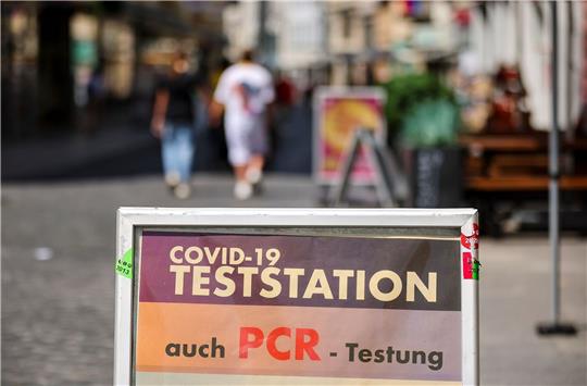 Ein Schild weist in Halle auf eine PCR-Teststation hin.