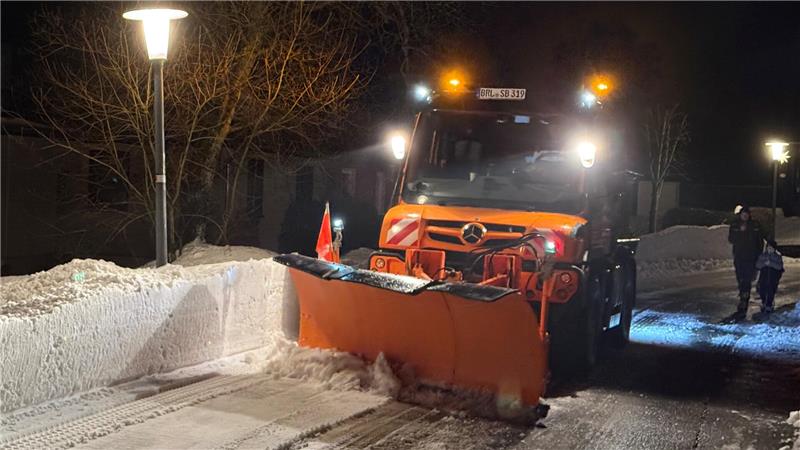 Das Foto zeigt einen Schneeschieber, der den Schnee an den Fahrbahnrand drückt.