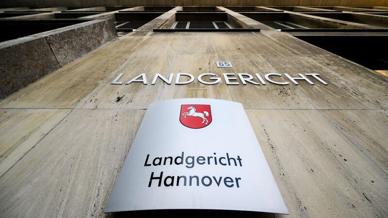 Ein Schriftzug und ein Schild hängen am Landgericht Hannover.
