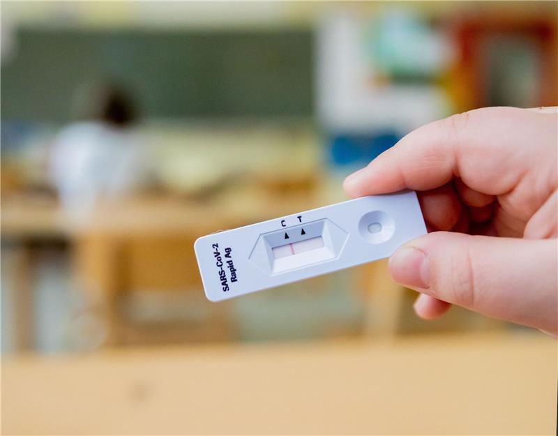 Zahl der mit Corona infizierten Schüler geht weiter zurück Ein Schüler hält einen negativen Corona-Schnelltest in der Hand.