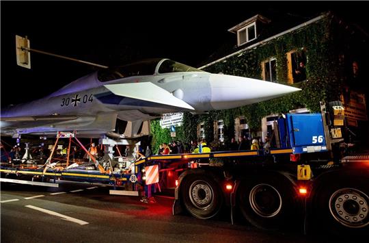 Ein Schwertransporter fährt mit einem einen ausgemusterten Eurofighter durch Jever.