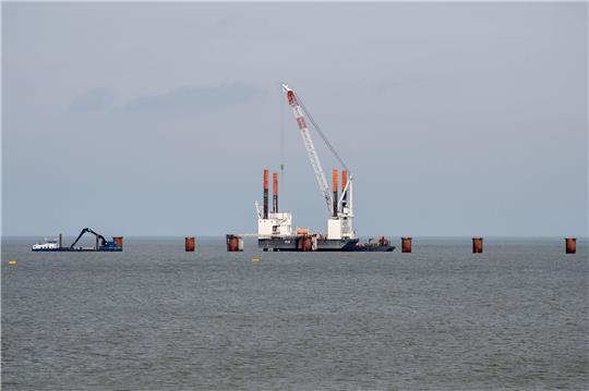 Ein Schwimmkran ist während der Bauarbeiten für einen Anleger, der für ein zweites LNG-Terminal in Wilhelmshaven benötigt wird, im Einsatz.