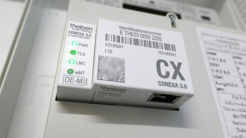 Weißes elektronisches Gerät mit Aufschrift 'CX CONEXA 3.0' und mehreren grünen Kontrollleuchten, montiert an einer Wand oder einem Schaltschrank