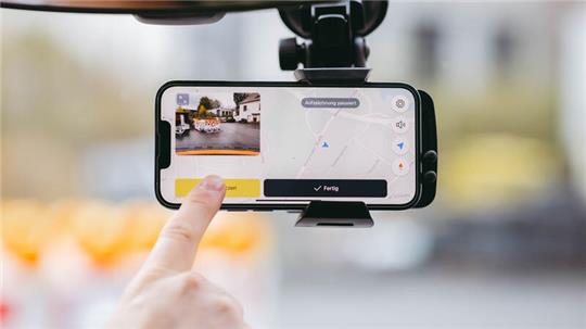 Auf dem Foto zeigt eine Hand auf das Display eines Smartphones, auf dem die Vialytics-App zu sehen ist.