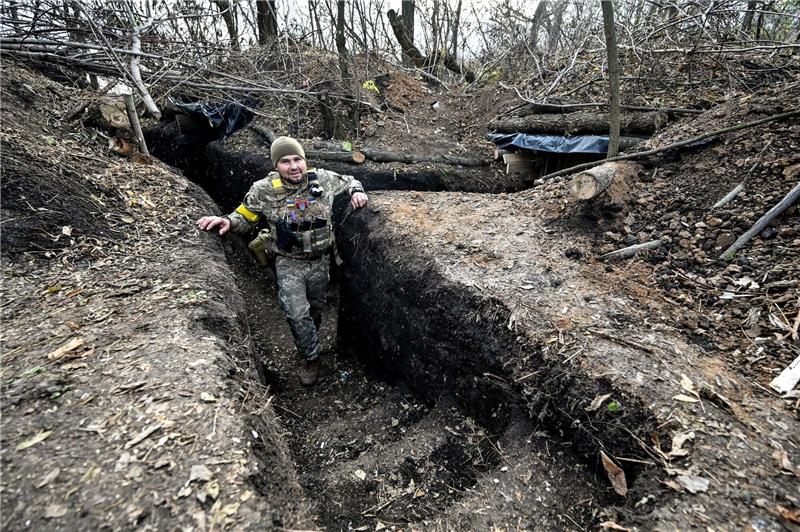 Ein Soldat der ukrainischen Streitkräfte steht in einem Graben.