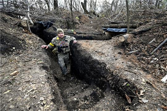 Ein Soldat der ukrainischen Streitkräfte steht in einem Graben.