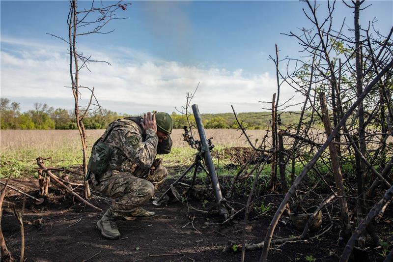 Krieg gegen die Ukraine: So ist die Lage Ein Soldat einer Mörser-Einheit der ukrainischen Streitkräfte hält sich die Ohren zu, während er auf feindliche Stellungen in den Vororten der Stadt Bachmut feuert.