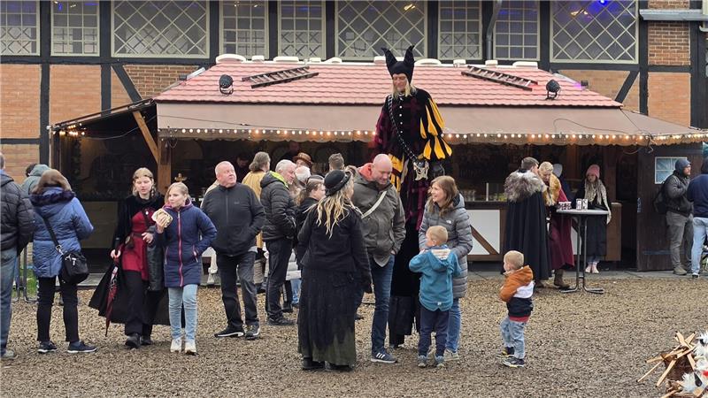 Ein Stelzenläufer inmitten von Besuchern.
